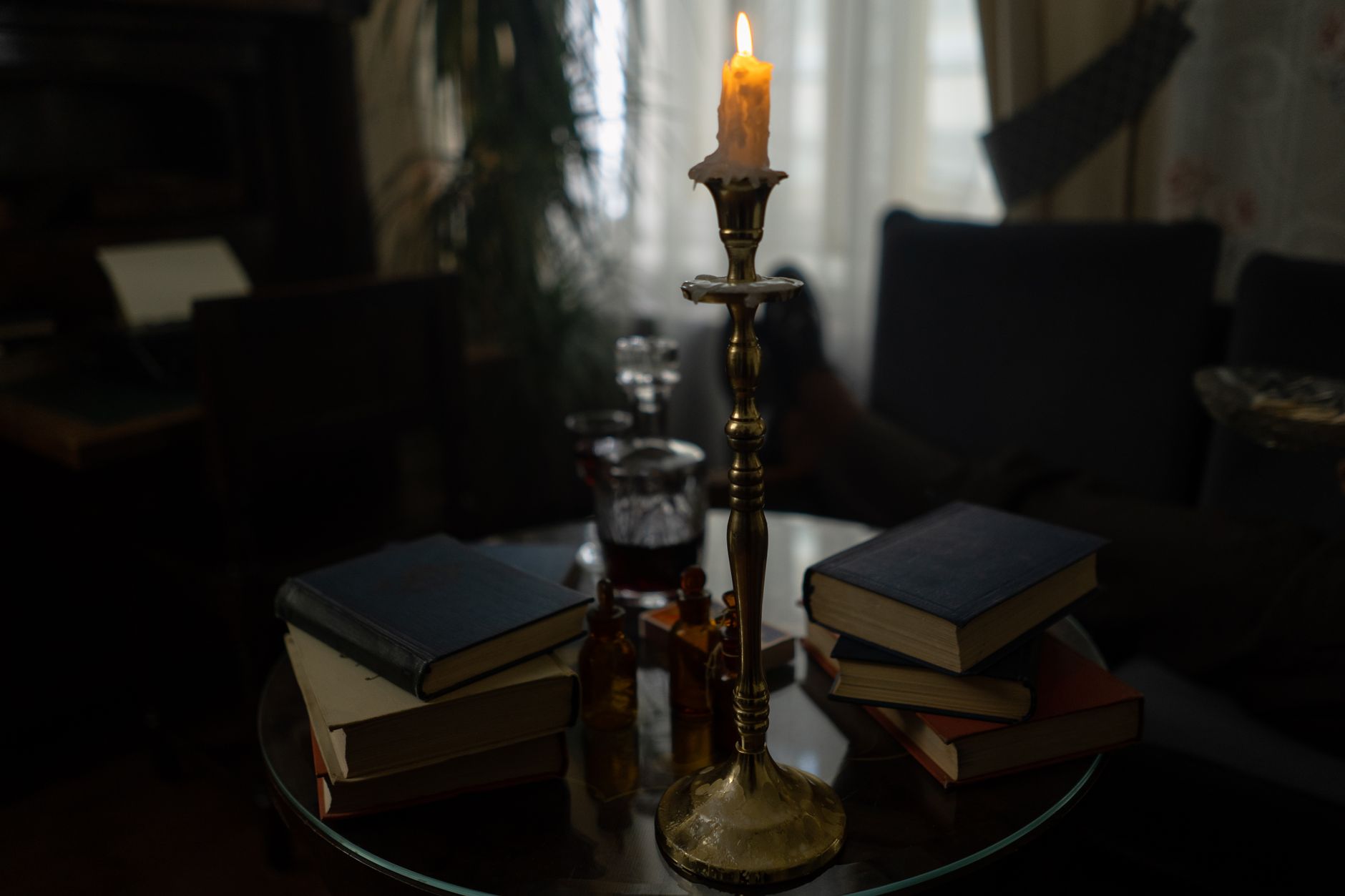 A lighted candle on a gold candle holder, illustrating the Kybalion as a written distillation of Hermetic doctrine