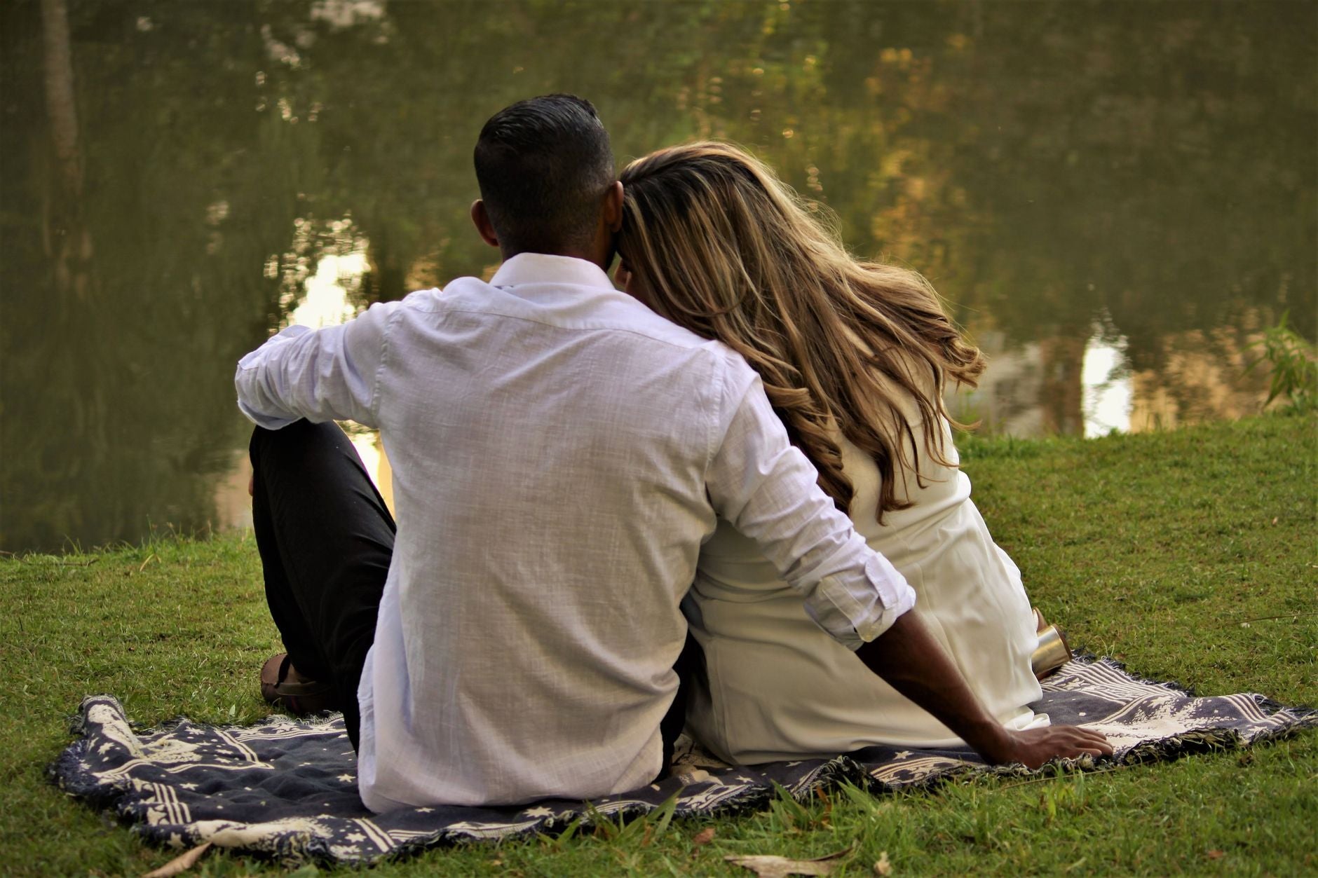 Why Your Inner State Determines Relationship Quality — a couple sitting close together by water, calm and present with each other