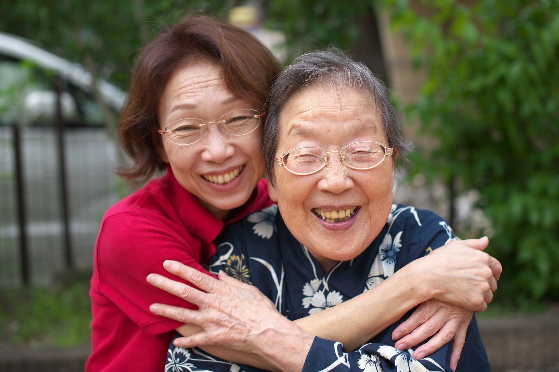 Elderly mother embracing adult daughter — family bond and inherited patterns