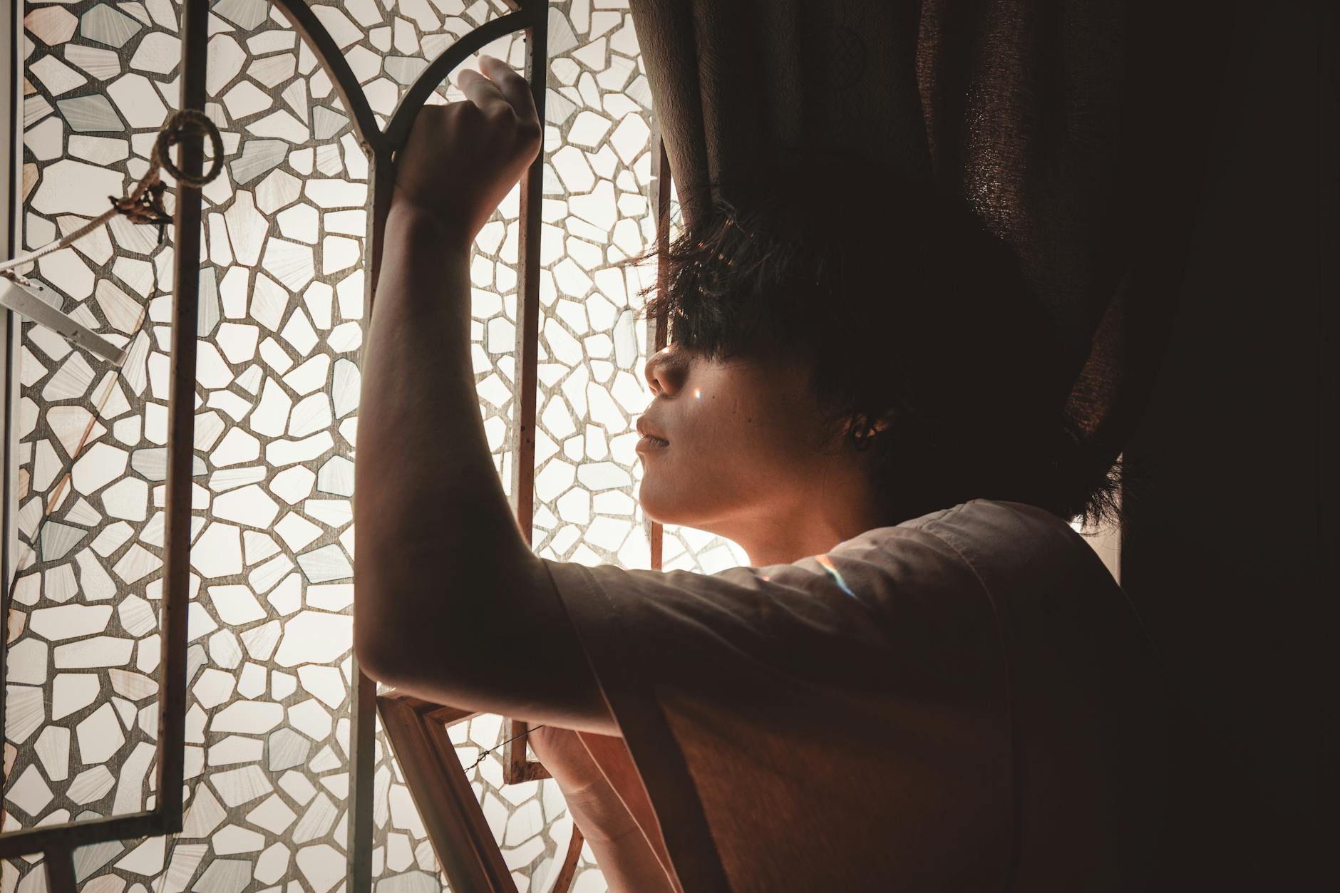 A person thinking by a window, weighing a major decision that analysis cannot settle