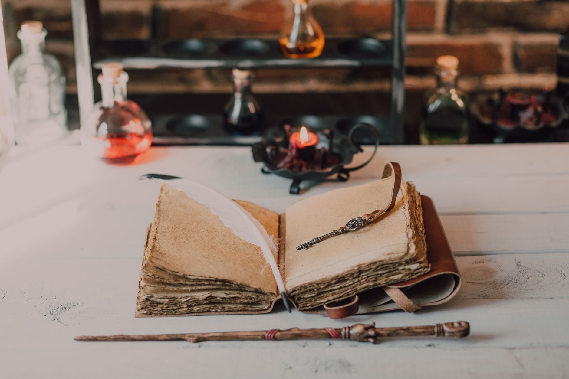 Vintage spellbook with quill and wand on a wooden table — Western esoteric practitioner workspace