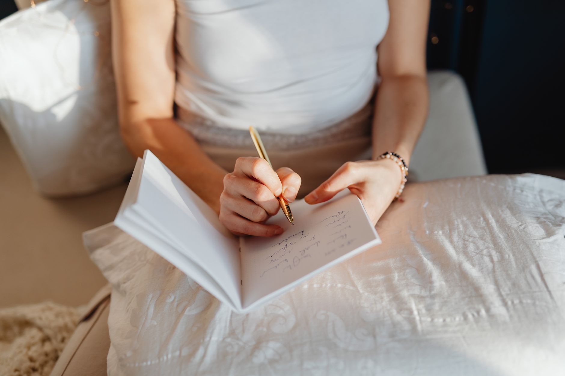 A woman writing notes in a notebook by morning light — the practice of logging signs during the response window