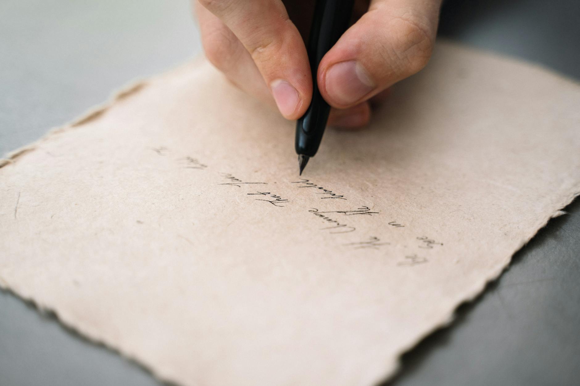 A hand writing on paper, drafting a spiritual petition by hand