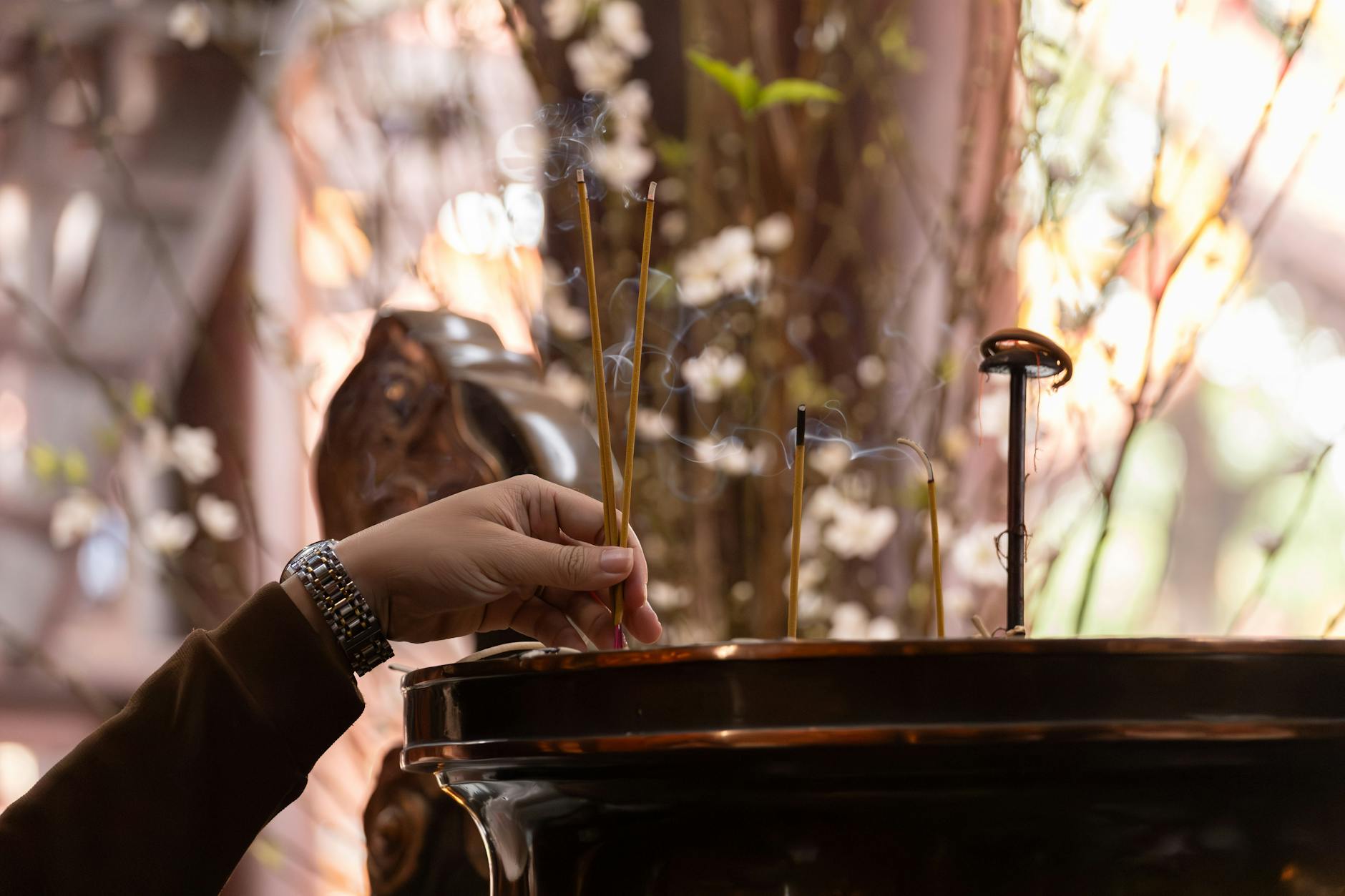 A hand lighting incense, a traditional esoteric cleansing practice