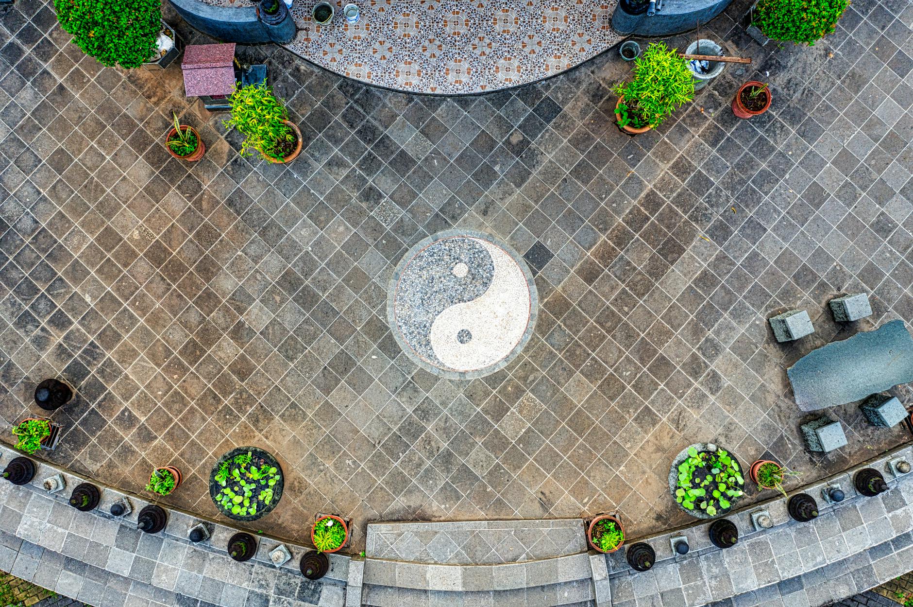 Yin and yang symbol set into a courtyard floor, illustrating active and receptive halves of one structure