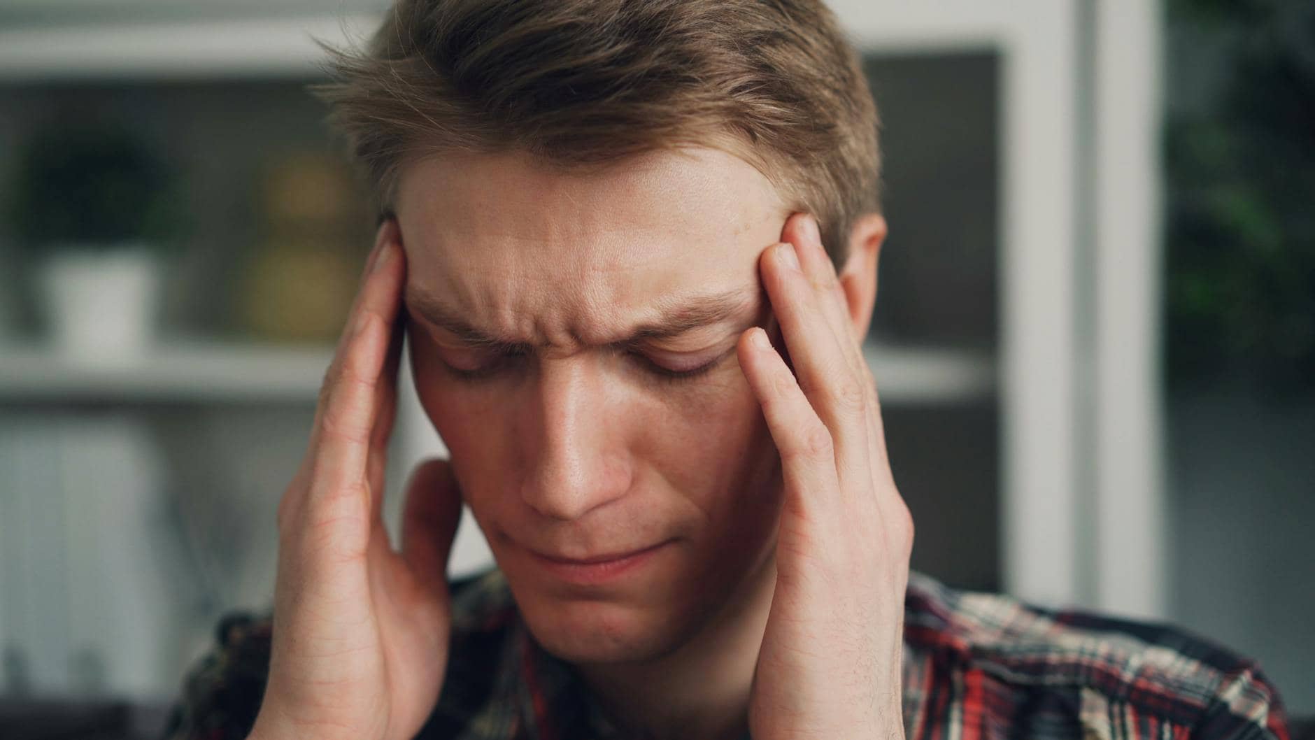 A man rubbing his temples with a worried look — evil-eye symptoms misread as stress