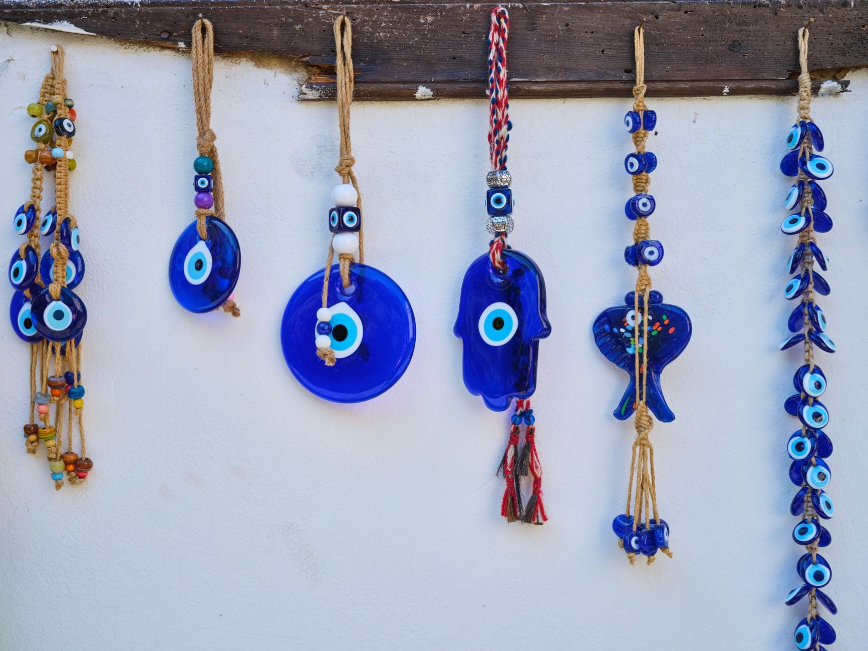 Blue evil eye protection charms hanging — talisman against family envy