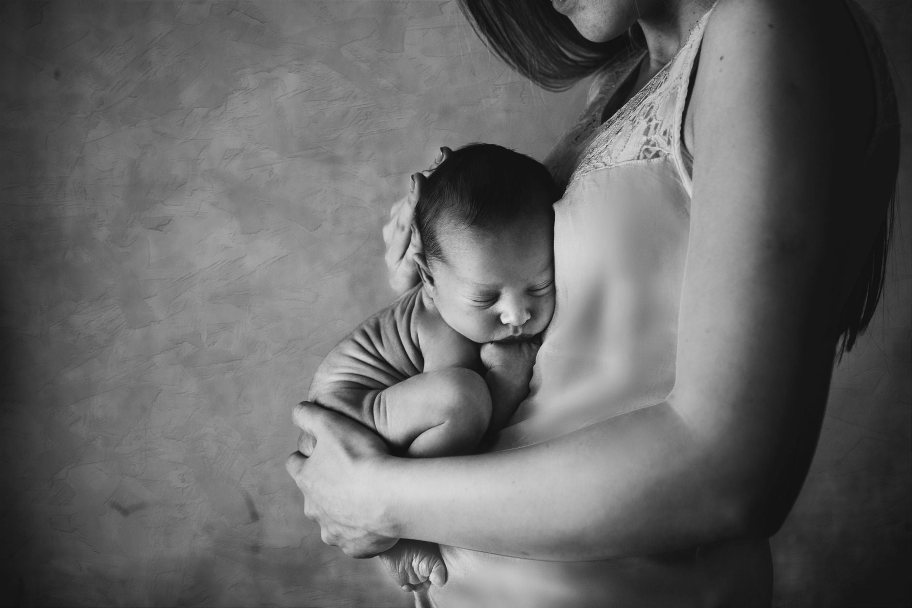 Mother gently shielding her sleeping child — the natural protective stance of the parent field