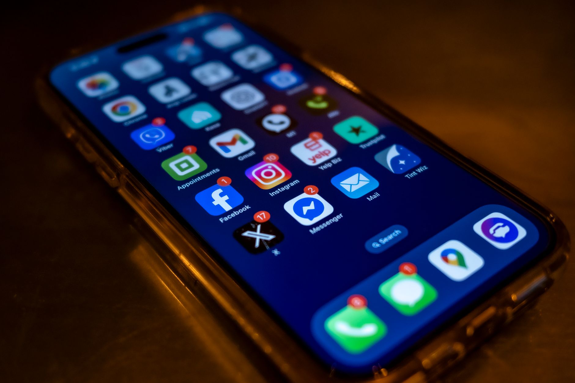 Smartphone screen displaying social media notifications in a dim setting — the attention economy in operation